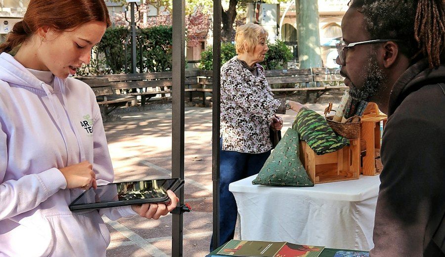 Volontaria con un tablet a uno stand all'aperto