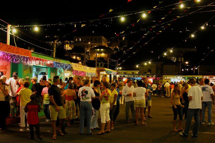 Festa di paese la sera, con luci e stand